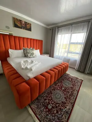 a large orange bed in a room with a window at Shibar farm house Mpumalanga in eLundi