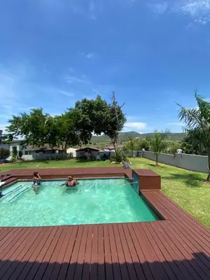 two people are in a swimming pool in a yard at Shibar farm house Mpumalanga in eLundi