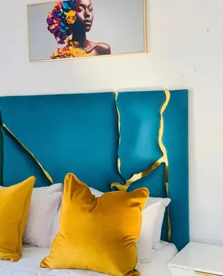 a bed with yellow pillows and a blue headboard at Shibar farm house Mpumalanga in eLundi