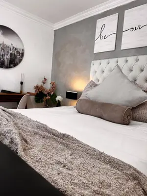 a bedroom with a large white bed with a large headboard at Cozy Suburban Escape in Benoni