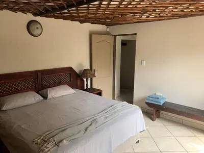 a bedroom with a bed and a clock on the wall at Wabisabi the wild at your doorstep in Marloth Park