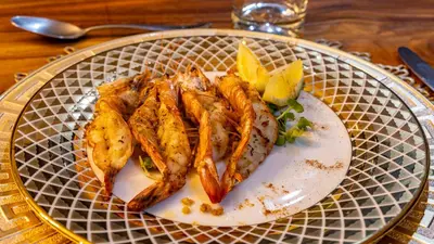 a plate of food with fish and potatoes on a table at Ingwenkala Luxury Safari Lodge - 5 Star in Hoedspruit