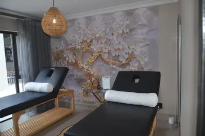 a living room with two chairs and a wall mural at Ingwenkala Luxury Safari Lodge - 5 Star in Hoedspruit
