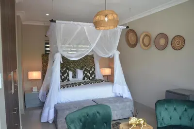 a bedroom with a canopy bed and two chairs at Ingwenkala Luxury Safari Lodge - 5 Star in Hoedspruit