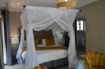 a bedroom with a white bed with a canopy at Ingwenkala Luxury Safari Lodge - 5 Star in Hoedspruit