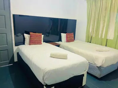 two beds in a hotel room withacers at Stay Inn Budget Rooms in Phalaborwa
