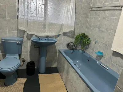 a bathroom with a toilet and a sink and a tub at Stay Inn Budget Rooms in Phalaborwa