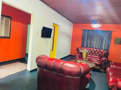 a living room with a leather couch and a table at Stay Inn Budget Rooms in Phalaborwa