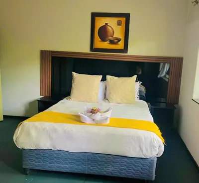 a bedroom with a large bed with flowers on it at Stay Inn Budget Rooms in Phalaborwa