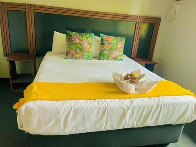 a bedroom with a large bed with a yellow blanket at Stay Inn Budget Rooms in Phalaborwa