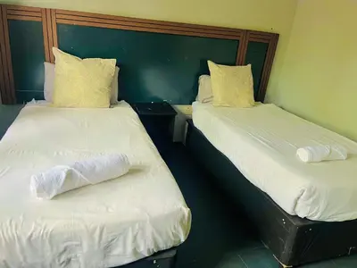 two beds sitting next to each other in a room at Stay Inn Budget Rooms in Phalaborwa