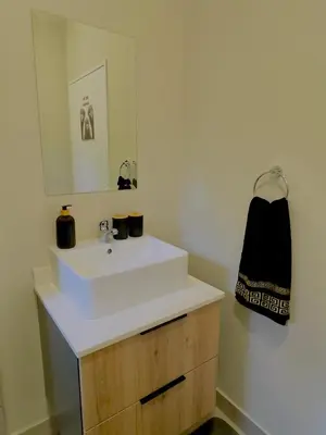 a bathroom with a white sink and a mirror at Dimension 1 in Midrand