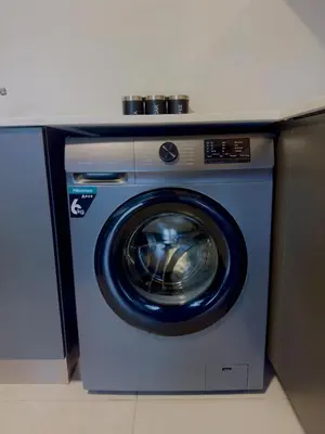 a blue washing machine sitting under a counter at Dimension 1 in Midrand