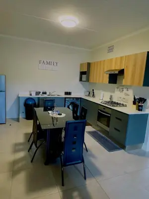 a kitchen with a table and chairs in a room at Dimension 1 in Midrand
