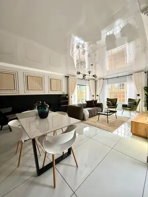 a white living room with a table and chairs at Luxury Redefined Home in Middelburg