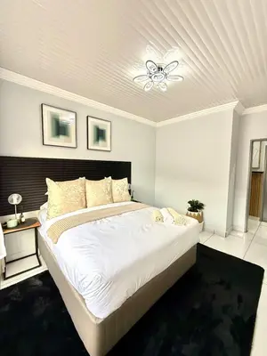 a bedroom with a large white bed with a white ceiling at Luxury Redefined Home in Middelburg