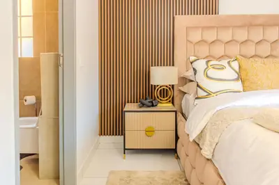 a bedroom with a bed and a side table with a lamp at Luxury Redefined Home in Middelburg