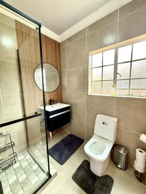a bathroom with a toilet and a sink at Luxury Redefined Home in Middelburg