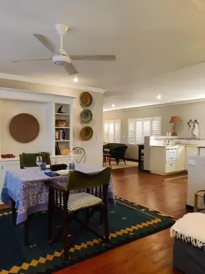 a living room with a table and a kitchen at The Loft in Kiepersol