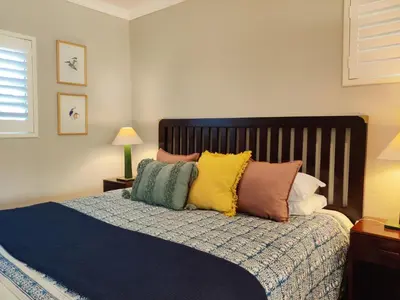 a bedroom with a bed with colorful pillows on it at The Loft in Kiepersol