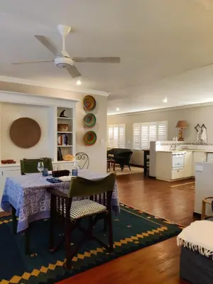 a living room with a table and a kitchen at The Loft in Kiepersol
