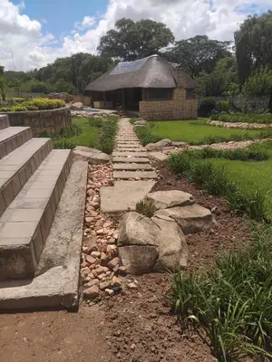 a garden with rocks and a building in the background at The Adress Events Venue in Midrand