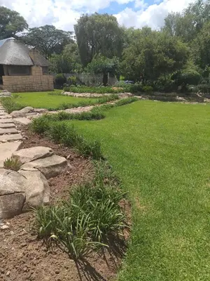 a garden with grass and rocks and a building at The Adress Events Venue in Midrand