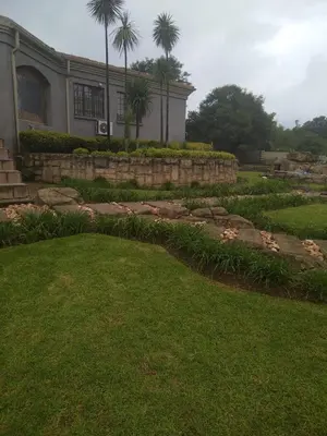 a house with a garden and a yard with grass and a building at The Adress Events Venue in Midrand