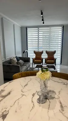 a living room with a table with a vase of flowers on it at 2 bedroom luxury Ellipse waterfall in Midrand
