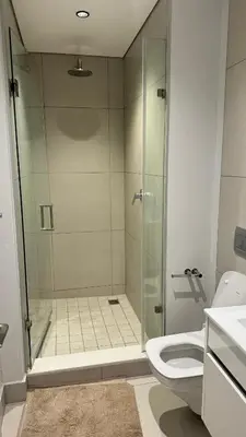 a bathroom with a glass shower and a toilet at 2 bedroom luxury Ellipse waterfall in Midrand