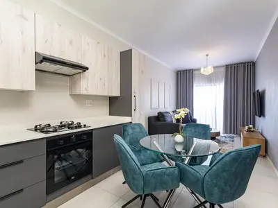 a kitchen and living room with a table and chairs at Binbin Serenity Suite in Midrand