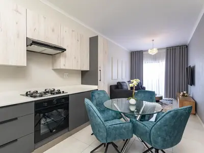a kitchen and living room with a table and chairs at Binbin Serenity Suite in Midrand