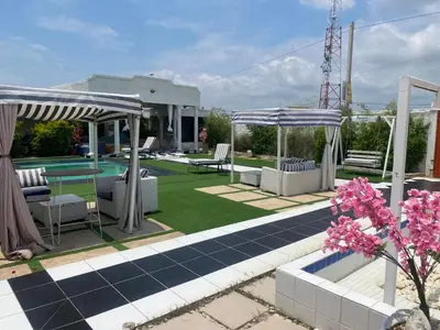 a garden with chairs and umbrellas and a pool at Mementos Guesthouse in Ga-Mapogo