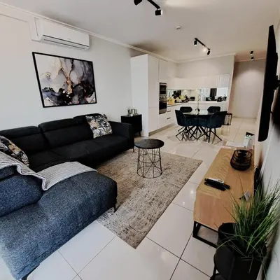 a living room with a couch and a table at Ellipse Waterfall luxurious and modern apartment in Midrand