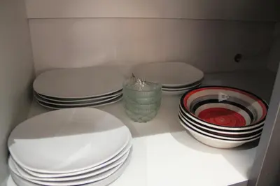 three plates and bowls sitting on a shelf in a kitchen at Cypress Nest Retreat in Midrand