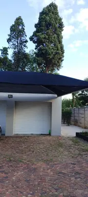 a garage with a blue roof on top of it at Cypress Nest Retreat in Midrand