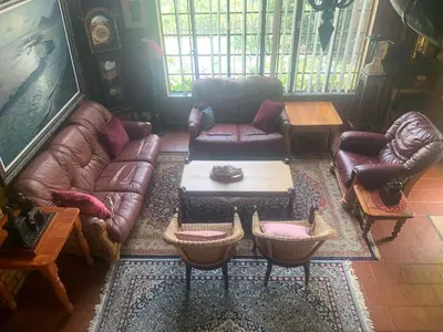 a living room with leather couches and a coffee table at Hermit Hill in Broederstroom