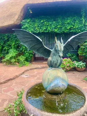 a statue of a fairy sitting on top of a fountain at Hermit Hill in Broederstroom
