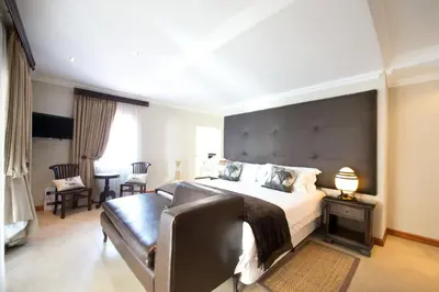 a bedroom with a large bed and a couch at The Finches Nest in Hammanskraal