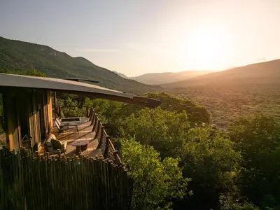 a house with a balcony with a view of the mountains at Few and Far Luvhondo in Waterpoort