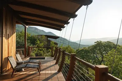 a deck with chairs and a view of the mountains at Few and Far Luvhondo in Waterpoort