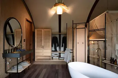 a bathroom with a tub and a sink and a mirror at Few and Far Luvhondo in Waterpoort