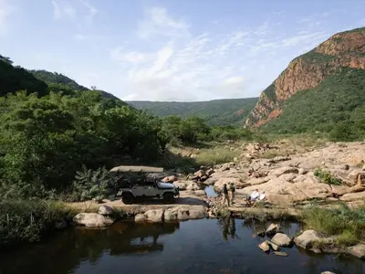 a jeep parked on the side of a river at Few and Far Luvhondo in Waterpoort