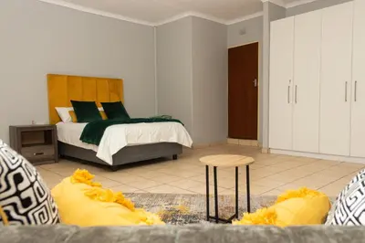a bedroom with a bed and a couch in a room at 22 Eland in Polokwane