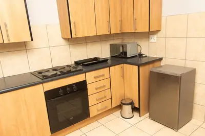 a kitchen with wooden cabinets and a stove and a refrigerator at 22 Eland in Polokwane
