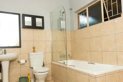 a bathroom with a tub and a toilet and a sink at 22 Eland in Polokwane