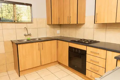 a kitchen with wooden cabinets and a stove top oven at 22 Eland in Polokwane