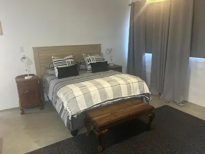 a bedroom with a bed with pillows and a bench at @144 Rabe in Mokopane
