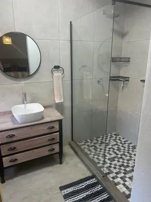 a bathroom with a shower with a sink and a mirror at @144 Rabe in Mokopane