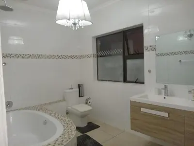 a bathroom with a tub and a toilet and a sink at Mountvista Guesthouse in Pretoria
